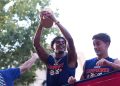 Lamine Yamal lifting the World Cup trophy during the bus parade.